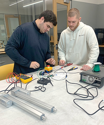 photo of two engineering students working on a walker